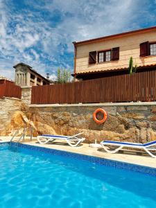 a swimming pool with chairs next to a house at Casa da Touça in Arcos de Valdevez