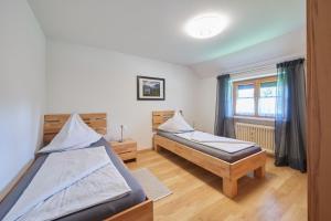 a bedroom with two beds and a window at Gästehaus Höfler in Bayerisch Gmain