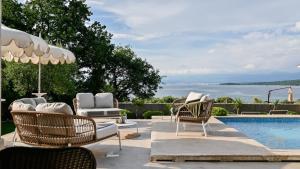 マリンスカにあるLuxury Villa Prova1のスイミングプールの隣に椅子とパラソル付きのプールがあります。