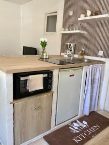 une cuisine avec un four micro-ondes au-dessus d'un comptoir dans l'établissement Appartement neuf, à Avignon