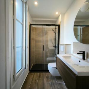 a bathroom with a toilet and a sink and a shower at Hotel Le Twelve in Paris