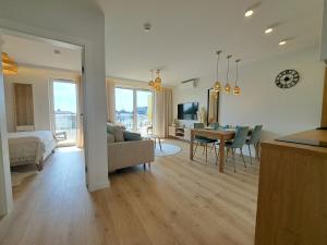 a living room and dining room with a couch and a table at Apartament Słoneczny & SPA Plażowa A208 in Grzybowo