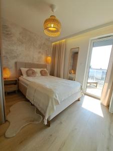 a bedroom with a large bed and a large window at Apartament Słoneczny & SPA Plażowa A208 in Grzybowo +33 photos