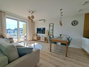 a living room with a couch and a table at Apartament Słoneczny & SPA Plażowa A208 in Grzybowo