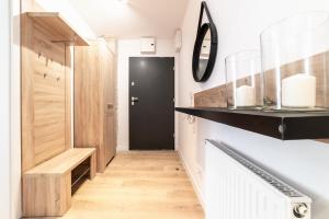 a hallway with a black door and wooden floors at Apartamenty Pamiątkowa 11, 2 rooms, self check in 24h in Poznań +36 photos