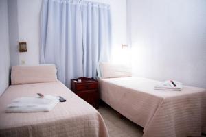 two beds sitting next to each other in a bedroom at Apart Hotel Río Dulce in Termas de Río Hondo +2 photos