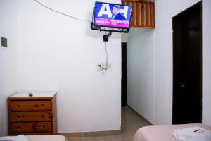 a tv hanging on a wall in a bedroom at Apart Hotel Río Dulce in Termas de Río Hondo