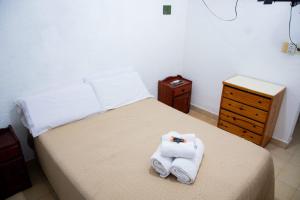 a bedroom with a bed with towels and a dresser at Apart Hotel Río Dulce in Termas de Río Hondo
