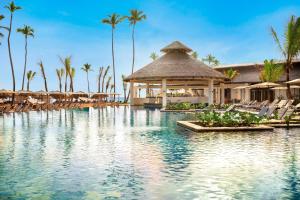 a resort swimming pool with chairs and a gazebo at Secrets Tides Punta Cana - All Inclusive in Punta Cana