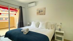 Un dormitorio con una cama grande con una manta azul. en MarketHome Jardines del Mar Pool View, en Puerto de Santiago 26 fotos más