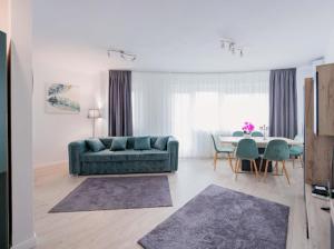 Una sala de estar con un sofá azul y una mesa. en Regia Apartament, en Oradea