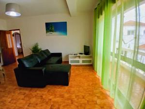a living room with a couch and a television at Casa Rocha Relax in Aljezur