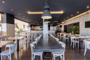 a dining room with wooden tables and white chairs at Suites Pamplona Plaza in Pamplona