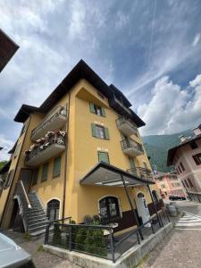a large yellow building with stairs in front of it at Effealatapartments - La Perla della Val di Sole in Dimaro