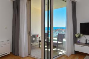 a room with sliding glass doors with a view of the ocean at Apartman Drobnjak Center-sea View in Budva