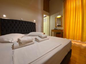 a bedroom with a large white bed with towels on it at Hotel EPIDAVROS in Nafplio