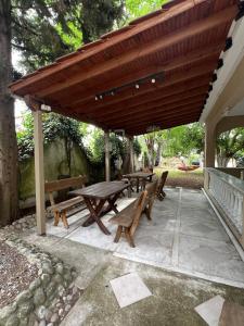 a picnic table and benches under a wooden canopy at Villa Katia in Asprovalta