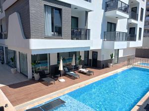 an external view of a building with a swimming pool at Flamingo - stylish apartments near the beach, in the heart of Alanya in Alanya