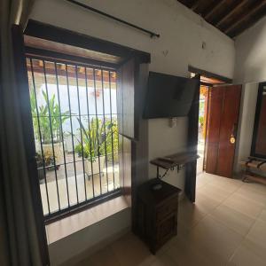 a room with a large window and a television at HOTEL PLAZA BOLIVAR MOMPOX ubicado en el centro histórico con parqueadero interno in Mompos