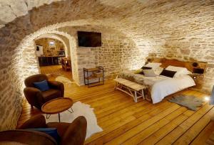 a bedroom with a bed and a stone wall at Le Marceau Spa Chablis in Chablis