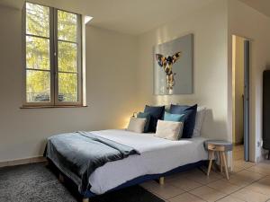 a bedroom with a large bed with blue pillows at L'atelier casse-noisettes-gitesdanslain in Pont-dʼAin +2 photos