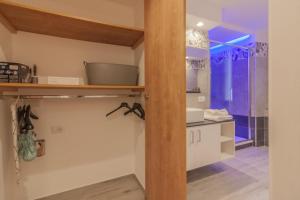 a kitchen with white cabinets and a wooden shelf at Casa Bambina in Varenna +45 photos