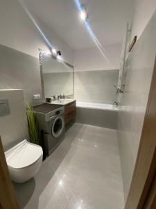 a bathroom with a toilet a sink and a washing machine at Go2Nati apartament in Gdańsk +15 photos