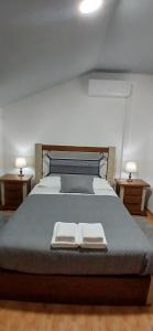 a bedroom with a large bed with two night stands at Ferradosa GuestHouse in São João da Pesqueira
