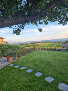 a green yard withestones in the grass at Casa Nataly Chianti - Jeky Stay in Castelnuovo Berardenga