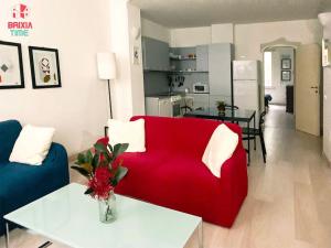 a living room with a red couch and a table at Brixia Time Case - La casa delle stelle in Brescia