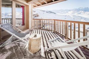 a porch with a chair and a table and a stump at Hotel Pashmina Le Refuge in Val Thorens +153 photos