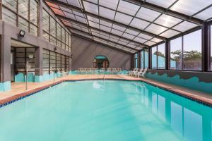 a large swimming pool with chairs and tables at Howard Johnson by Wyndham Williamsburg in Williamsburg