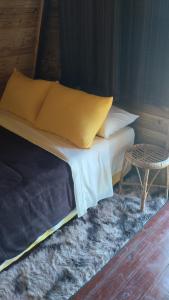 a bed with yellow pillows and a table in a room at Sítio são longuinho in Extrema +15 photos
