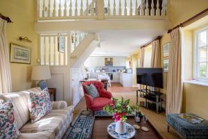 a living room with a couch and a tv at Saratoga Cottage in Bruern