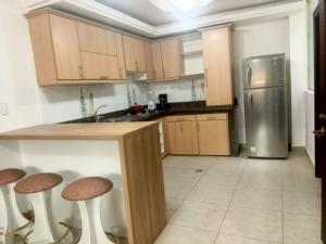 Alojamiento San Cayetano في لوخا: مطبخ مع كونتر مع الكراسي وثلاجة