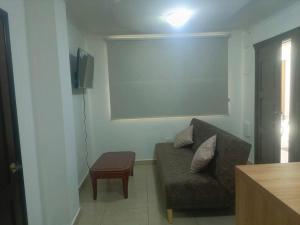 Alojamiento San Cayetano في لوخا: غرفة معيشة مع أريكة وتلفزيون