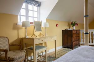 a bedroom with a desk with a mirror and a chair at Saratoga Cottage in Bruern +12 photos