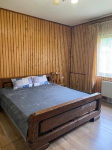a bedroom with a large bed with wooden walls at U Bogdana in Yaremche