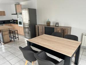 a kitchen with a table and chairs and a refrigerator at Maison de ville 2 chambres in Dangé