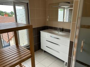 a bathroom with a sink and a mirror at Maison de ville 2 chambres in Dangé