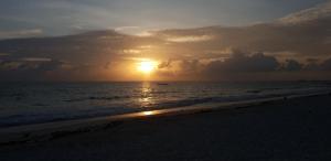 a sunset on the beach with the sun setting at Jambiani Guest Lodge Garden in Jambiani