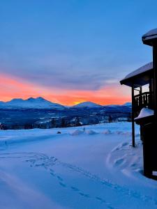 a winter sunset with footprints in the snow at Målselv Fjellandsby Apartments in Bardufoss