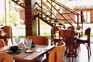 a restaurant with tables and chairs and a staircase at Terrasa Solar Hotel in Icaraí