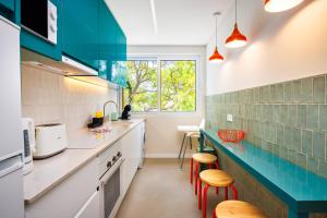 une cuisine avec des placards blancs et du carrelage bleu dans l'établissement Vilamoura Dream House QR2, à Quarteira