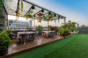 a rooftop patio with tables and chairs and plants at Gulmohar Mansion - A Boutique Stay in Jaipur