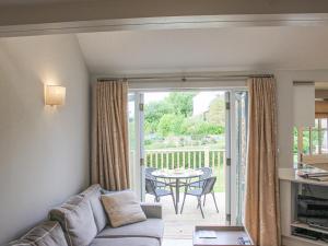 ein Wohnzimmer mit Sofa und Tisch in der Unterkunft 5 Keeper's Cottage, Hillfield in Dartmouth