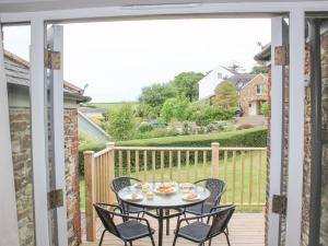 eine Terrasse mit Tisch und Stühlen auf einem Deck in der Unterkunft 5 Keeper's Cottage, Hillfield in Dartmouth + 19 Fotos