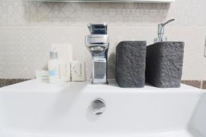 a bathroom sink with a bottle of soap and two towels at La Rosa di Capri in Capri +10 photos