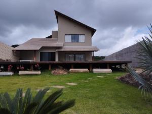 ein Haus mit einem grünen Hof davor in der Unterkunft Castelo fort in Caparaó Velho