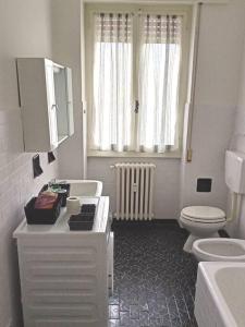 a white bathroom with a toilet and a sink at CASA di ALE Incantevole appartamento con parcheggio gratuito in Verbania +15 photos